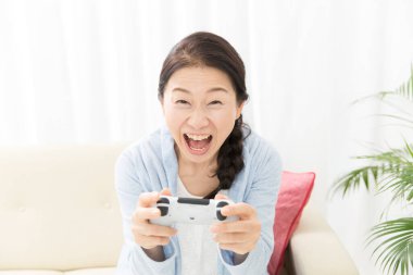Evde video oyunu oynayan Asyalı kadın