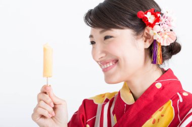 Geleneksel Japon kimonosuyla dondurma yiyen güzel genç bir kadının portresi.