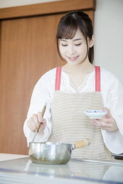 Güzel Asyalı kadın mutfakta yemek yapıyor.