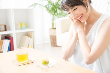 Pasta ve meyve suyuyla Asyalı kadın. 