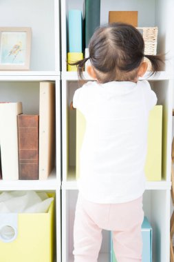 Kitaplara uzanan genç bir kız.