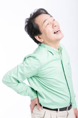  Beyaz arka planda sırt ağrısı çeken yaşlı bir Asyalı..