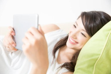 Tablet bilgisayar kullanan Asyalı kadın