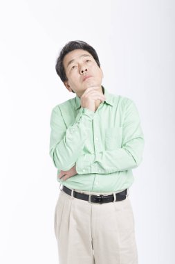 Asyalı işadamı, elleri çenesinde, beyazı izole bir şekilde düşünüyor..