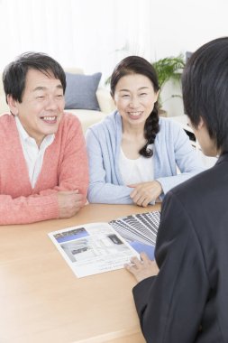 Üst düzey Asyalı çift bir emlakçıyla daire almayı tartışıyor.