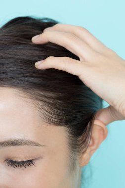 Güzel Asyalı kadının portresi kafa masajı yapıyor. 