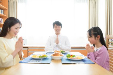 Aile yemekten önce yemek masasında dua eder.