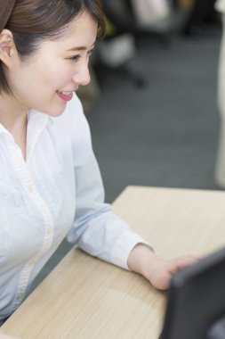 Bilgisayarda çalışan genç bir kadın. 