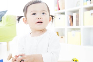 Odada oyuncağı olan Asyalı bir çocuk.