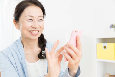 Kapat telefonu olan güzel, yaşlı Asyalı kadını.