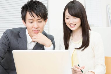 young asian man and woman with laptop  in office
