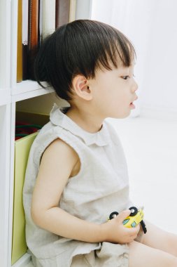 Evde oyuncağı olan Asyalı bir çocuk. 