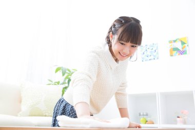 Genç Asyalı kadın ev işi yapıyor.