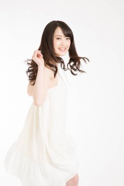 Beyaz arka planda beyaz elbiseli Asyalı kadın