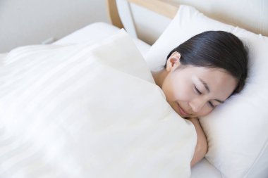 Kadın yatakta uzanıyor ve evde uyuyor.