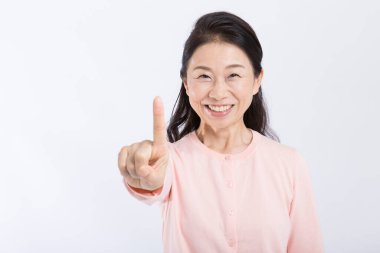 Asyalı son sınıf öğrencisi parmaklarıyla bir şey gösteriyor. 