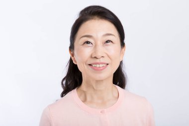 Gülümseyen olgun kadın gülümseyerek kameraya bakıyor.