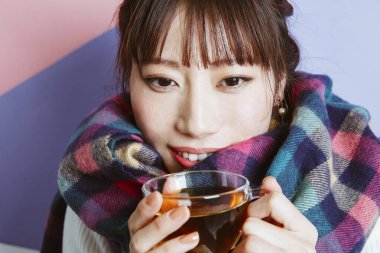 Çay içen Asyalı kadın, stüdyo fotoğrafı. 