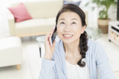 Kapat telefonu olan güzel, yaşlı Asyalı kadını.