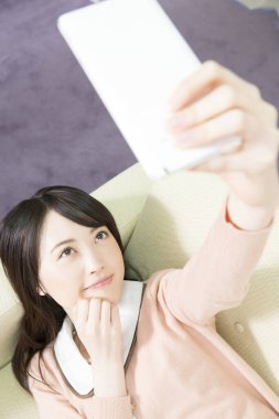 Genç bir kadın evde selfie çekiyor.