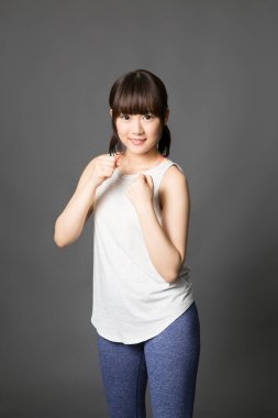 Asyalı genç kadın, tecrit edilmiş arka planda eğitim görüyor.