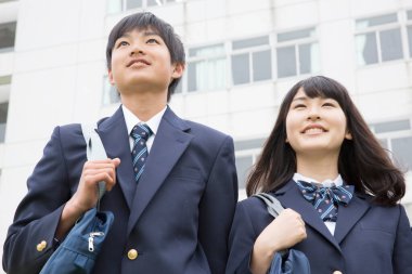 Okulda çantalı genç Japon öğrencilerin portresi.