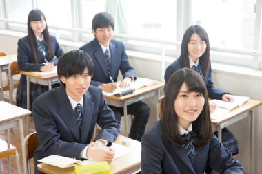 Genç Japon öğrenciler sınıfta okuyor.