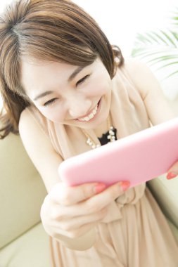 Akıllı telefon kullanan güzel Asyalı kadın, portreyi kapat.