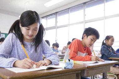 Japon ilkokul öğrencileri sınıfta yazıyor. eğitim kavramı