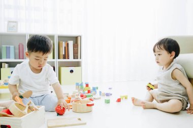 İki çocuk renkli tahta oyuncaklarla oynuyor.