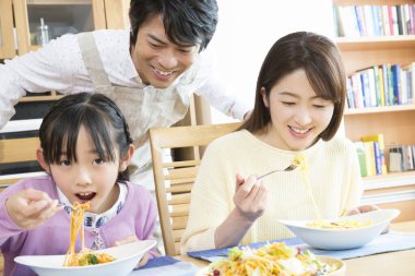 Genç bir aile mutfakta öğle yemeği yiyor.