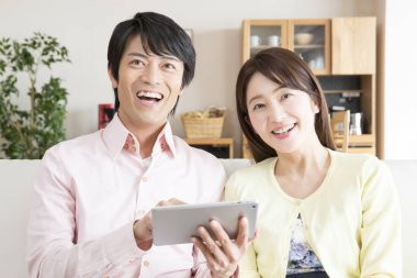 Evde tablet kullanan Asyalı çift. 