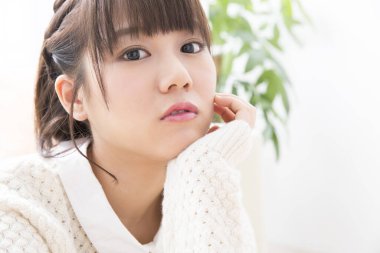 Beyaz kazaklı genç Asyalı kadın.