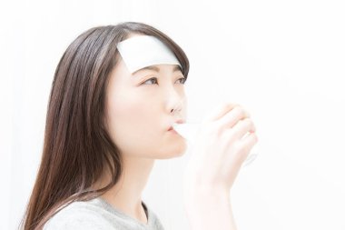 Genç hasta kadın bir bardak su içiyor. 