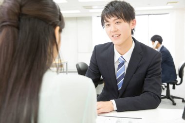 Genç Asyalı işadamı kadın müşteriyle birlikte çalışıyor.