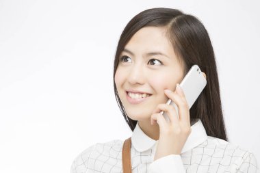 Beyazlar üzerinde izole edilmiş akıllı telefon kullanan güzel Japon kadının portresi.