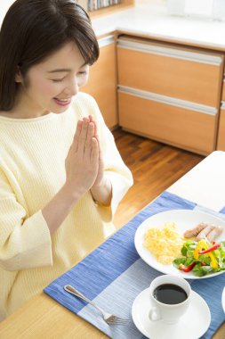 Genç kadın kahvaltısını yatak odasında yapıyor.