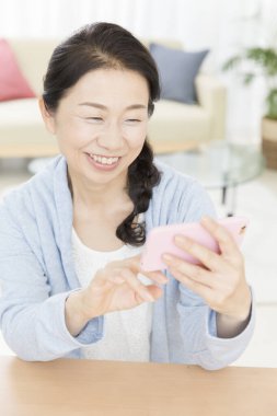 Kapat telefonu olan güzel, yaşlı Asyalı kadını.