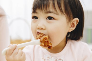 Güzel Asyalı kız evde Japon yemeği yiyor.