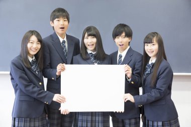 Boş tahtayı tutan bir grup öğrenci