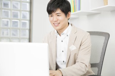 İşadamı ofiste dizüstü bilgisayarla çalışıyor.