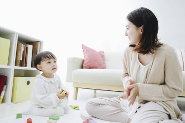 Evde annesiyle oynayan tatlı Asyalı kız.