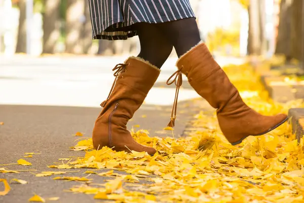 Sarı akçaağaç yapraklı kız sonbahar parkında.
