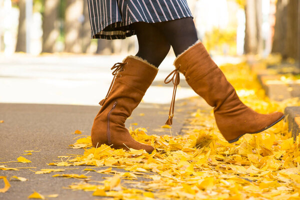 Девушка с желтыми листьями клена в осеннем парке.