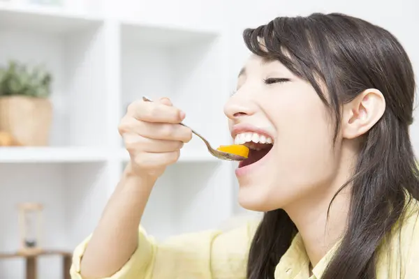 日本の若い女性が自宅でゼリーを食べる笑顔 — ストック写真