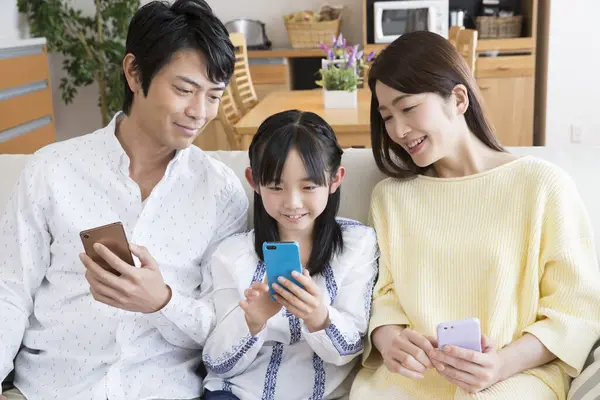 Evdeki Koltukta Akıllı Telefonları Olan Mutlu Bir Aile — Stok fotoğraf