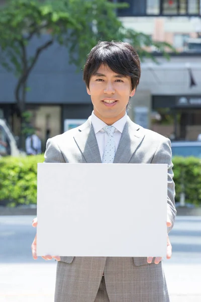 Guapo Profesional Asiático Hombre Negocios Sosteniendo Blanco Cartel Sonriendo Cámara —  Fotos de Stock
