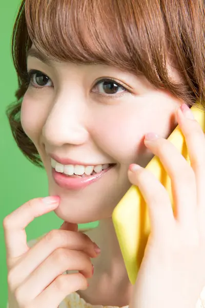 Güzel Japon Kadının Portresi Yeşil Arka Planda Akıllı Telefondan Konuşuyor — Stok fotoğraf
