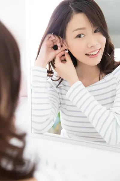 Güzel Asyalı Kadın Aynanın Önünde Küpe Takıyor — Stok fotoğraf