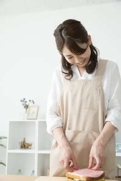 Krásná Asijská Žena Dělat Chutné Sendvič Kuchyni Stůl — Stock fotografie